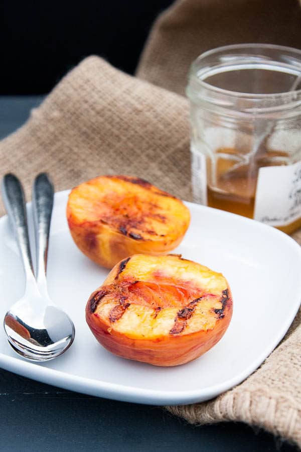 Grilled Peach Halves with Granola and Honey make a special variation on a fruit and granola breakfast - or swap the yogurt with vanilla ice cream for a light summer dessert!