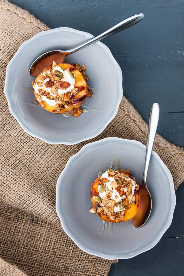Grilled Peach Halves with Granola and Honey make a special variation on a fruit and granola breakfast - or swap the yogurt with vanilla ice cream for a light summer dessert!
