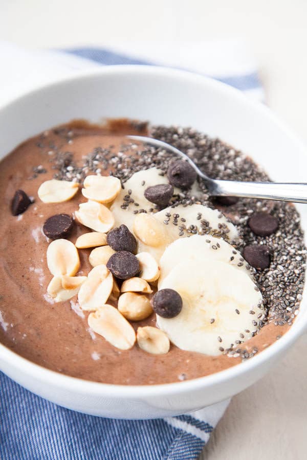 This Chocolate Peanut Butter Smoothie Bowl tastes like a treat, but is so healthy! Frozen bananas are mixed with a little almond milk, peanut butter, cocoa powder, dates for sweetness, and chia seeds for thickness.