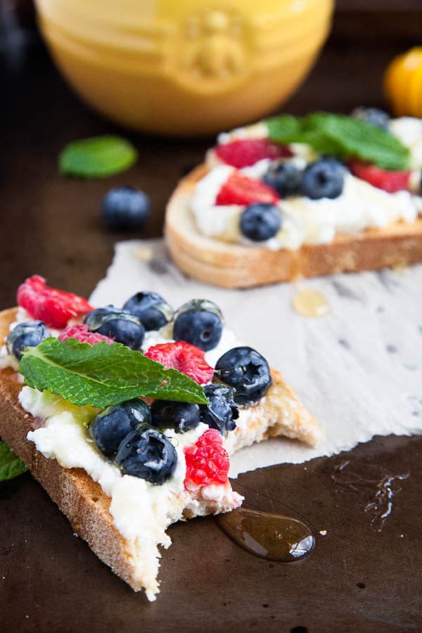 Generous smears of creamy ricotta cheese are paired with blueberries, raspberries, drizzled with lots of honey and tangy mint. A spring breakfast.