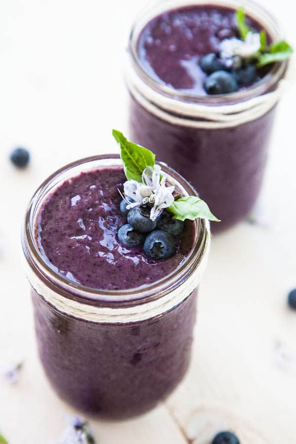 Fresh basil leaves are added to a classic blueberry smoothie, creating a refreshing twist in this healthy breakfast smoothie.