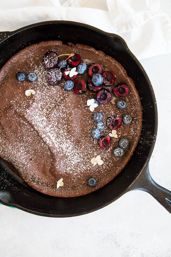 Chocolate dutch baby pancake is the perfect little breakfast treat when eaten with fresh berries, a sprinkle of powdered sugar, and a drizzle of maple syrup.