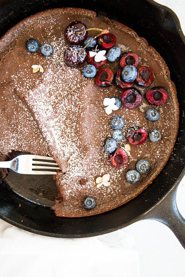 Chocolate dutch baby pancake is the perfect little breakfast treat when eaten with fresh berries, a sprinkle of powdered sugar, and a drizzle of maple syrup.