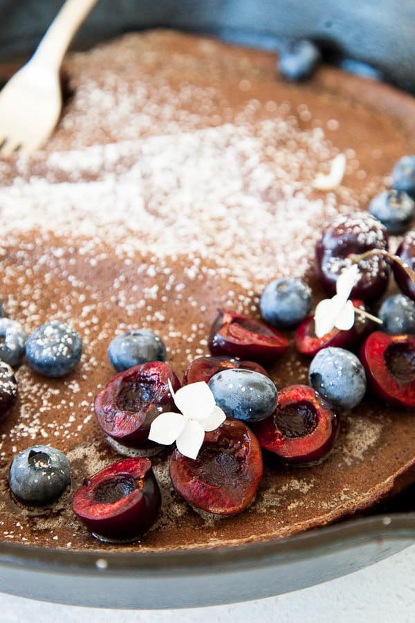 Chocolate dutch baby pancake is the perfect little breakfast treat when eaten with fresh berries, a sprinkle of powdered sugar, and a drizzle of maple syrup.