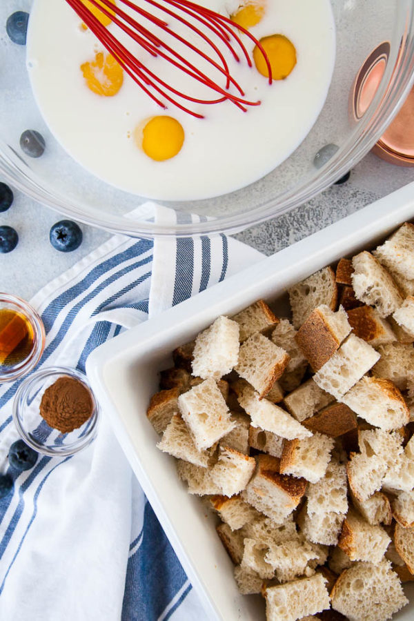 Whisking eggs and bread cubes for Blueberry Cream Cheese French Toast Bake