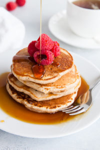 Stack of whole wheat pancakes with syrup.