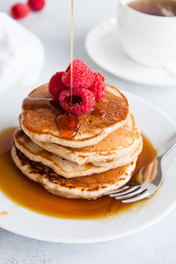 Stack of whole wheat pancakes with syrup.