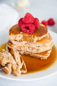 A forkful of whole wheat pancakes with syrup.