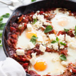 Cast iron pan with Shakshuka and poached eggs