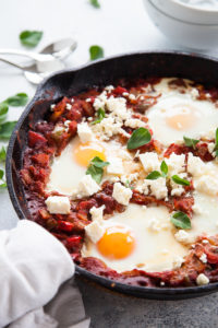 Cast iron pan with Shakshuka and poached eggs